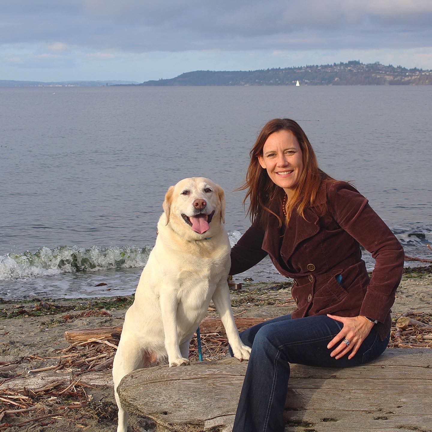 Sadie, a lab, and Taeya Lauer, her owner, on the beach at Alki